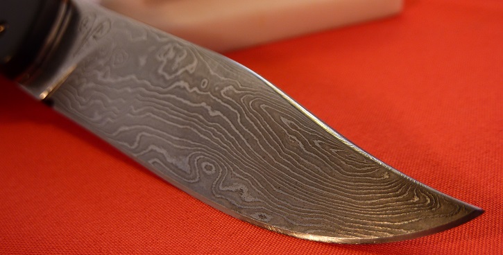 Folding knife piémontais, damasteel blade, ebony and reconstitute red stone handle